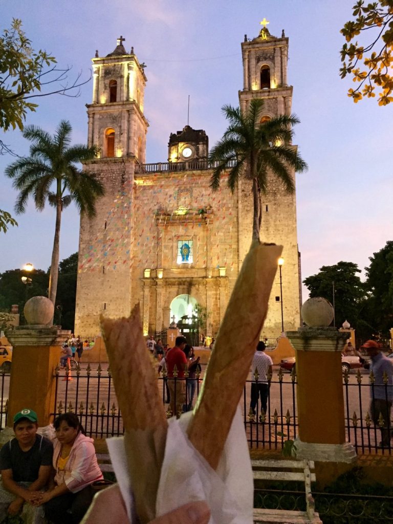 Two crispy pancakes - marquesitas in front of a church in Valladolid, Yucatan. One was with cheese and nutella and the other one with cheese and dulce de leche.